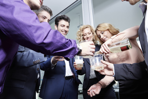 Deutschland, Neuss, Geschäftsleute beim Feiern im Büro, lizenzfreies Stockfoto