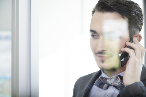 Germany, Neuss, Portrait of a business man using mobile phone stock photo