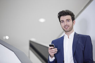 Germany, Neuss, Portrait of a business man using mobile phone - STKF000745