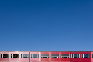 Deutschland, Bayern, München, rote und rosafarbene mobile Gebäude, die als Wohngebäude, Kindergärten oder Schulen genutzt werden - TCF003727