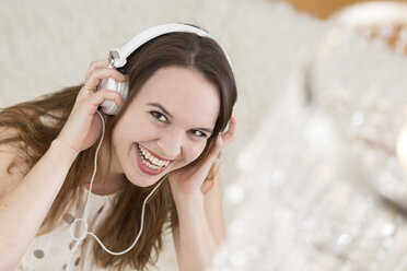 Laughing young woman wearing headphones - DRF000326