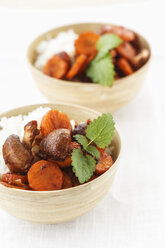 Two bowls of Thai jasmine rice with coconut milk and fried carrots and crimini mushrooms - EVGF000271