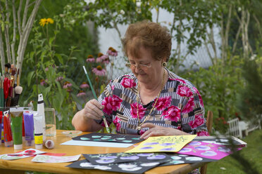 Deutschland, Bayern, Ingolstadt, ältere Frau beim Malen im Garten - MABF000185