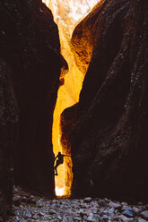 Australien, Westaustralien, Kimberley, Purnululu National Park, Bungle Bungle, Mann beim Klettern am Echidna Chasm - MBE000950