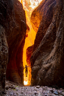 Australien, Westaustralien, Kimberley, Purnululu National Park, Bungle Bungle, Mann beim Klettern am Echidna Chasm - MBE000930