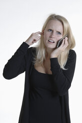 Annoyed young woman on the phone - CRF002527