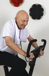 Porträt eines alten Mannes, der an einem Fitnessgerät trainiert - LAF000320