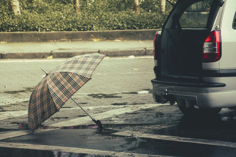 Brasilien, Sao Paulo, Regenschirm und Auto auf der Straße, lizenzfreies Stockfoto