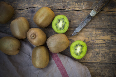 Kiwis (Actinidia deliciosa) and pocketknife on wooden table - LVF000381