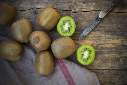 Kiwis (Actinidia deliciosa) und Taschenmesser auf Holztisch - LVF000381