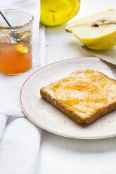 Quitten (Cydonia oblonga), selbstgemachtes Quittengelee und eine Scheibe Toast auf einem weißen Holztisch - LVF000382