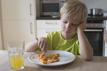 Gelangweilter Junge sitzt am Esstisch - CRF002535