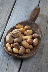 Wooden shovel with blend of nuts on wooden table - CSF020511