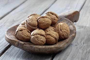 Hölzerne Schaufel mit Walnüssen (Juglans) auf Holztisch - CSF020506