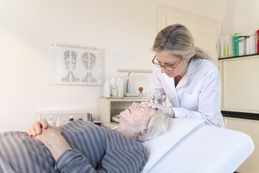 Heilpraktikerin gibt älterer Frau Injektionsakupunktur - TCF003737