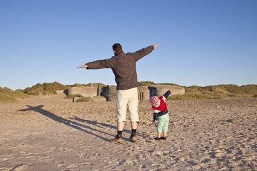 Denmark, Blavand, little girl and her father playing on the beach - JFEF000241