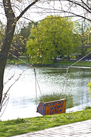 Deutschland, Schleswig-Holstein, Kiel, Schaukel am See mit Spruch von Occupy, lizenzfreies Stockfoto