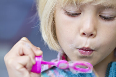Portrait of little girl making soap bubbles - JFEF000245