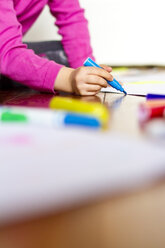 Little girl painting with blue felt tip pen, partial view - JFEF000265