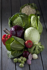 Cabbage varieties and other vegetables on grey wooden table - CSF020583