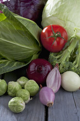 Cabbage varieties and other vegetables on grey wooden table - CSF020582