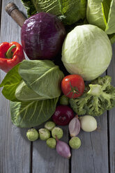 Cabbage varieties and other vegetables on grey wooden table - CSF020579