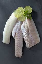 Fischfilets von Kabeljau, Rotbarsch und Seelachs mit Scheiben auf grauem Grund - CSF020555