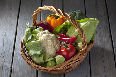 Basket with different vegetables on grey wooden table - CSF020544