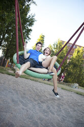 Jugendliches Paar schaukelt auf dem Spielplatz - MVC000043