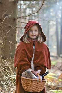 Portrait of little girl masquerade as Red Riding Hood standing in the wood - CLPF000042