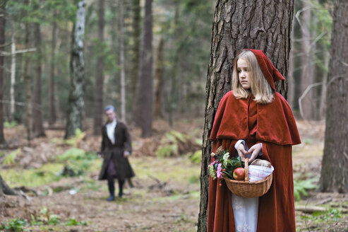 Girl masquerade as Red Riding Hood hiding behind a tree in the wood - CLPF000045