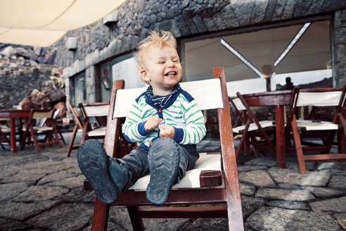 Spanien, Lanzarote, lachender kleiner Junge auf der Terrasse eines Restaurants - MFF000693