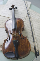 Antike Geige und Geigenbogen auf Musiknoten liegend - CRF002545