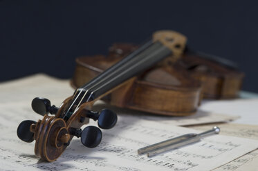 Antike Geige und Stimmgabel auf Musiknoten liegend - CRF002542