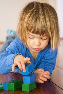 Kleines Mädchen spielt mit blauen und grünen Holzbausteinen - LVF000393