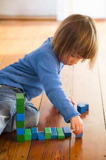 Kleines Mädchen spielt mit blauen und grünen Holzbauklötzen - LVF000396