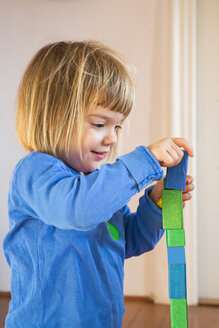 Kleines Mädchen spielt mit blauen und grünen Holzbauklötzen - LVF000392