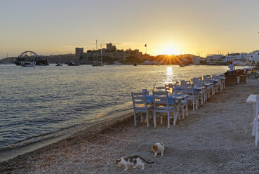 Türkei, Bodrum, Burg von St. Peter und Restaurant am Strand bei Sonnenuntergang - SIE004905