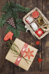 Weihnachtsgeschenk und Verpackungsmaterial auf Holztisch - ECF000421