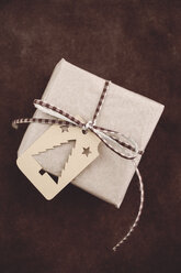 Weihnachtsgeschenk mit Geschenkanhänger auf rustikalem Leder - ECF000417