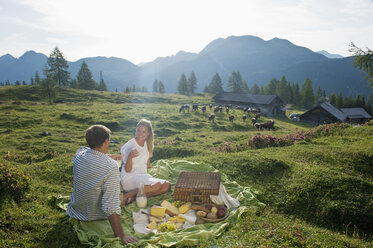 Österreich, Bundesland Salzburg, Altenmarkt-Zauchensee, Pärchen beim Picknick auf Almwiese - HHF004719