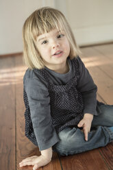 Portrait of little girl sitting on wooden floor - LVF000402