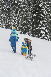 Austria, Salzburg Country, Altenmarkt-Zauchensee, Family walking in snow, pulling sledge - HHF004663