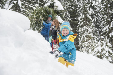 Austria, Salzburg Country, Altenmarkt-Zauchensee, Family walking in snow, carrying Christmas tree - HHF004665