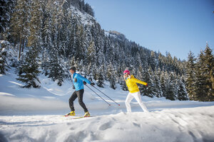 Österreich, Salzburger Land, Altenmarkt-Zauchensee, Junges Paar beim Skilanglauf - HHF004657