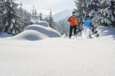 Österreich, Bundesland Salzburg, Altenmarkt-Zauchensee, Paar beim Schneeschuhwandern in Winterlandschaft - HHF004690