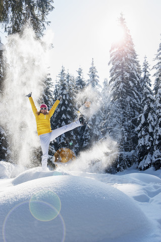 Austria, Salzburg State, Altenmarkt-Zauchensee, Woman with snowshoes jumping in winter landscape stock photo