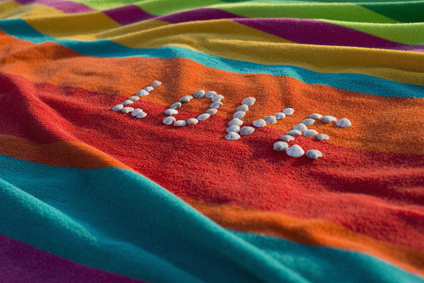 The word 'Love' formed by shells lying on a multicolored bath towel stock photo