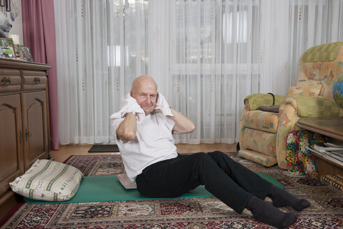 Alter Mann macht Übungen in seinem Wohnzimmer - LAF000392