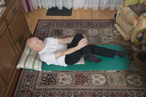Alter Mann macht Übungen in seinem Wohnzimmer - LAF000375